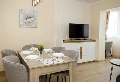 a dining room with a table with chairs and a television at Stylish Apartment - the Heart of Central Varna by Flat Manаger in Varna City