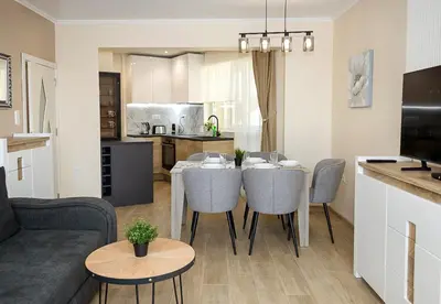 a living room and kitchen with a table and chairs at Stylish Apartment - the Heart of Central Varna by Flat Manаger in Varna City