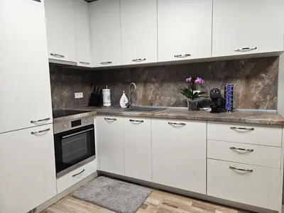 a white kitchen with white cabinets and a sink at Central Flat, Close to the beach in Burgas City