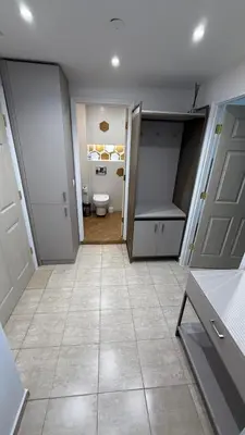 a bathroom with a toilet and a room with doors at Apartment Zornitsa I Panoramic Sea View in Sozopol