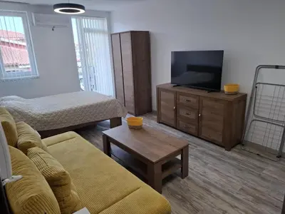a living room with a couch and a flat screen tv at РАВДА Лазур Аурелия in Ravda