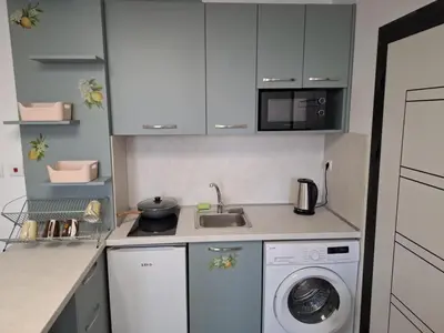 a kitchen with a sink and a washing machine at РАВДА Лазур Аурелия in Ravda