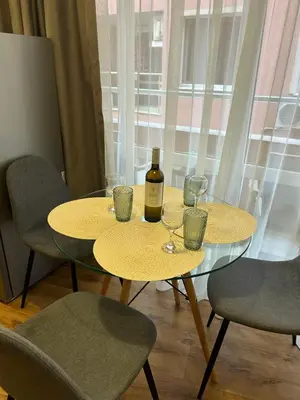 a table with a bottle of wine and glasses on it at Судио Диксан in Pomorie