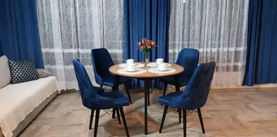 a table and chairs in a room with blue curtains at Ela, Kedar 3 in Sveti Vlas