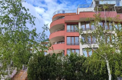 a tall red building with trees in front of it at Ela, Kedar 3 in Sveti Vlas