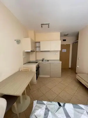 a small kitchen with a wooden table and a dining room at Royal Sun SP apartments in Sunny Beach