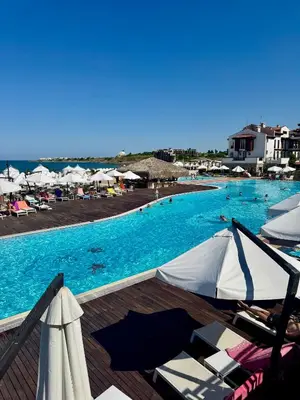 a large swimming pool with chairs and umbrellas at Casa Oasis Lozenets in Lozenets
