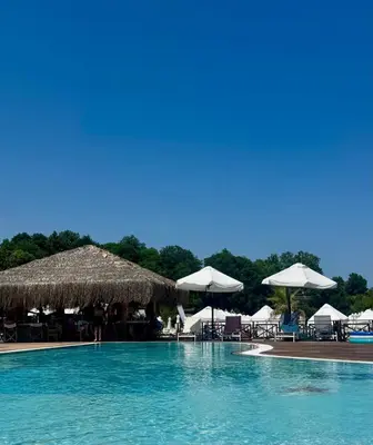 a swimming pool with chairs and umbrellas at Casa Oasis Lozenets in Lozenets