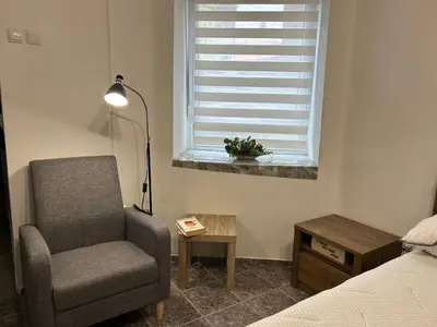 a bedroom with a chair and a table and a window at 3D Studio in Varna City
