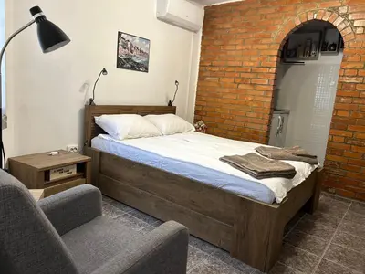 a bedroom with a bed and a brick wall at 3D Studio in Varna City