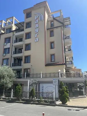 a hotel with a sign on the side of it at Raduga SP apartments St Vlas in Sunny Beach