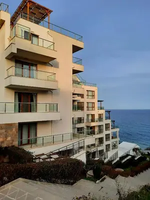 an apartment building with the ocean in the background at White Cliffs первая линия in Byala