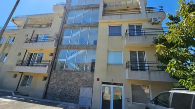 an apartment building with windows and a car parked in front at Апартаменты за гости Гавань in Byala
