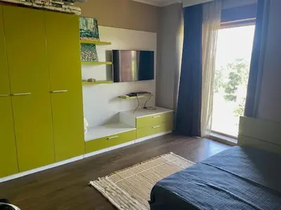a bedroom with green cabinets and a bed and a window at First Line Lozenez Beach Anron in Lozenets