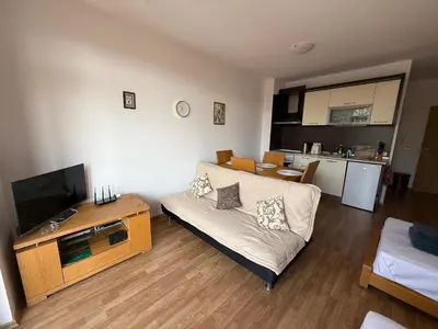 a living room with a couch and a television at Vineyards Resort, Aheloy - Studio 32 in Pomorie