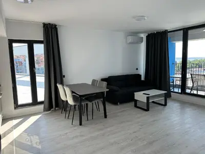 a living room with a table and a couch at Sozopol Beach Apartments in Sozopol