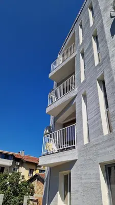 a tall building with balconies on the side of it at Геновева in Kiten
