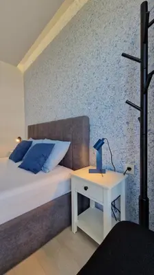 a bedroom with a bed and a table with a lamp at Геновева in Kiten