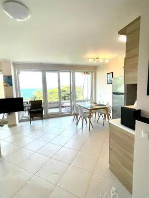 a kitchen with a table and a dining room with a view at Byla Sea side Apartament in Byala