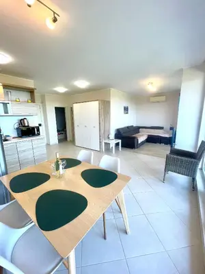 a kitchen and a living room with a table and chairs at Byla Sea side Apartament in Byala