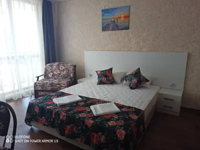 a hotel room with a bed and a chair at Студио под наем Елина 31 in Shkorpilovtsi