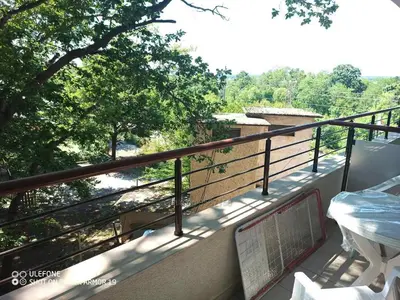 a balcony with a view of a river and trees at Студио под наем Елина 31 in Shkorpilovtsi