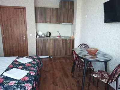 a small room with a table and a kitchen at Студио под наем Елина 31 in Shkorpilovtsi