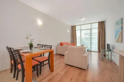 a dining room and living room with a table and chairs at Sunny Holiday Apartments in Sunny Beach
