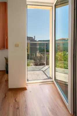 an empty room with a large sliding glass door at Sunny Holiday Apartments in Sunny Beach
