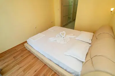 a bed with white sheets and pillows in a room at The Family Courtyard - Very LARGE 2BD Apartment by Flat Manаger in Ravda