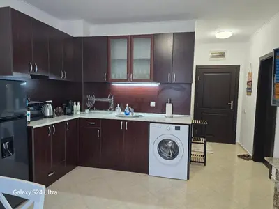 a kitchen with a washing machine in the middle at Elia Relax & Lux in Aheloy