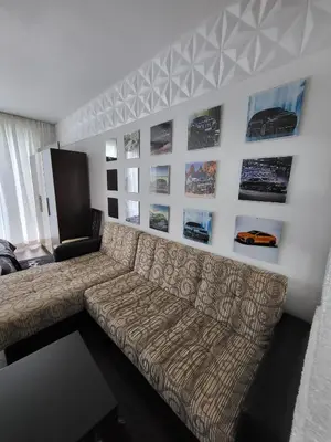 a living room with a couch and pictures on the wall at Sunny View SP apartments in Bŭnzareto