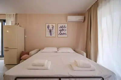 a bedroom with a bed with two towels on it at BellaViaStay, Flat Apolonia 1BD in Burgas City