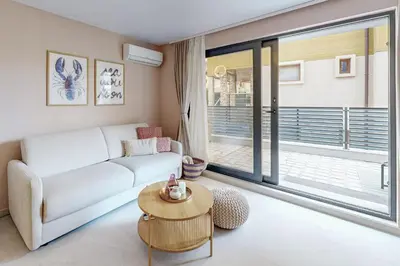 a living room with a white couch and a table at BellaViaStay, Flat Apolonia 1BD in Burgas City