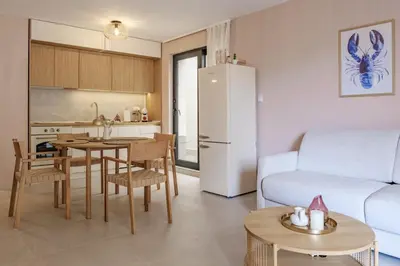 a kitchen and living room with a table and a refrigerator at BellaViaStay, Flat Apolonia 1BD in Burgas City