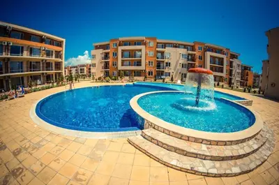 a swimming pool with a fountain in front of some buildings at Pool View, 2 Bedroom Apartment in Sunny Beach