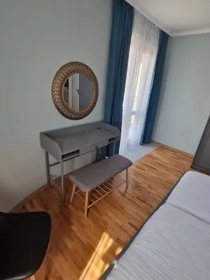 a bedroom with a desk and a mirror and a bed at Flowers Apartments in Nesebar