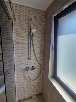 a shower in a bathroom with a glass window at Flowers Apartments in Nesebar