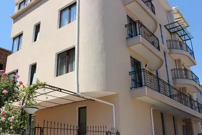 a white building with balconies on the side of it at Flowers Apartments in Nesebar
