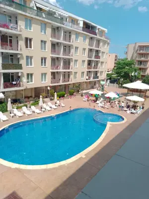 a swimming pool in front of a large building at 3 room apartment Sanny Day 2 in Sunny Beach