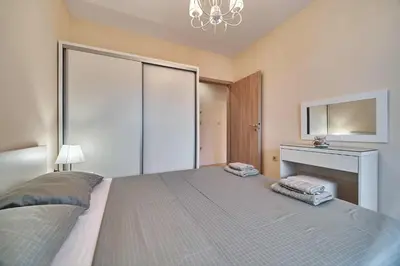 a bedroom with a large bed and a desk at Varna South Bay - Monk Apartment in Varna City