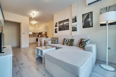 a living room with a couch and a table at Varna South Bay - Monk Apartment in Varna City