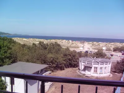 a view of a house with the ocean in the background at Apartment Stoyanovi in Primorsko