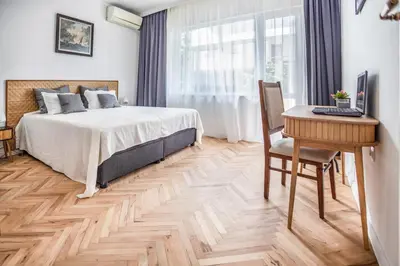 a bedroom with a bed and a desk with a computer at Downtown Central point Varna Apartment in Varna City