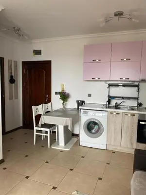 a kitchen with a washing machine and a table at Tryavna Beach Violet 42 in Sveti Vlas