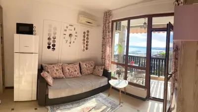 a living room with a couch and a balcony at Tryavna Beach Violet 42 in Sveti Vlas