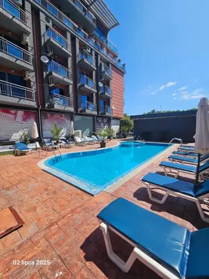 a swimming pool with lounge chairs next to a building at Cacao Residence in Sunny Beach