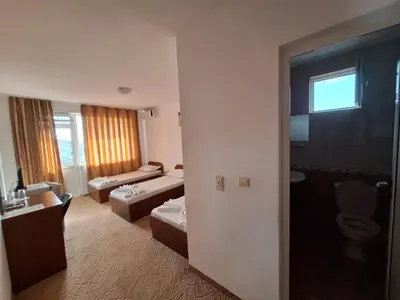 a hotel room with a bed and a bathroom at Къща за гости Авеню in Ravda