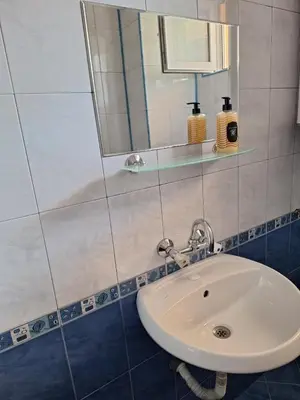 a bathroom with a white sink and a mirror at Къща за гости Авеню in Ravda