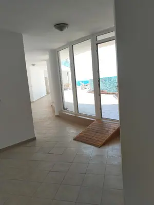 an empty room with a hallway with sliding glass doors at 2 Room Apartment Costa Calma Aheloy Bulgarien in Aheloy